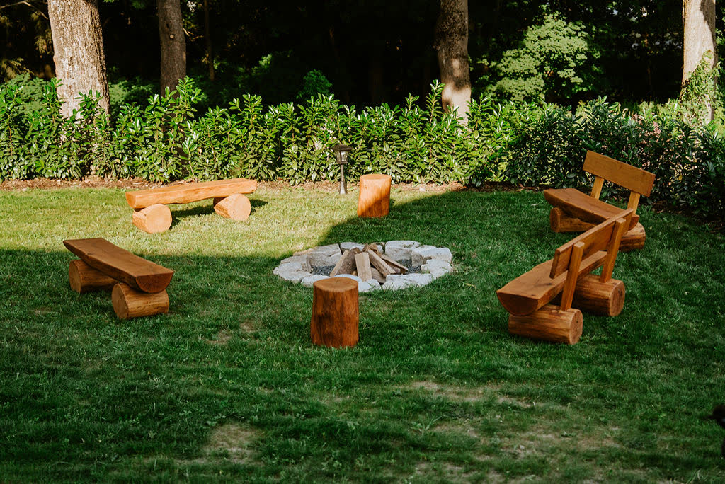 Fire pit with log benches in the garden of Polňačka Cottage