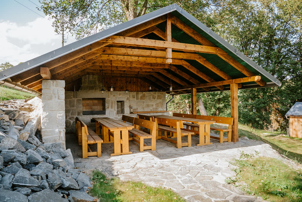 Covered outdoor kitchen with a grill at Polňačka Cottage