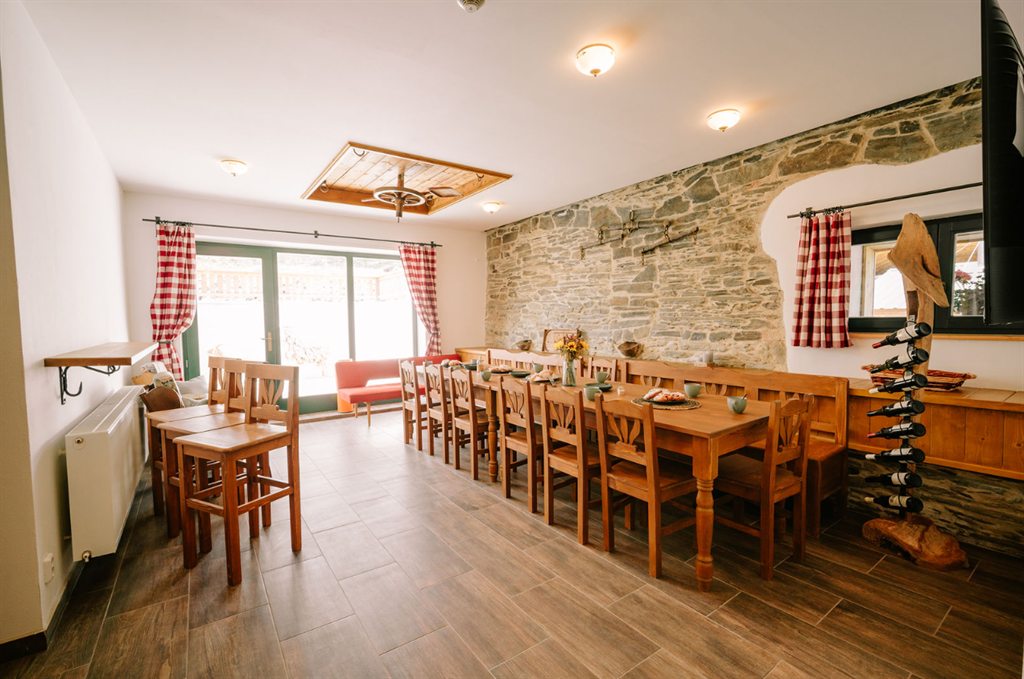 Large dining room with a long table and a stone wall